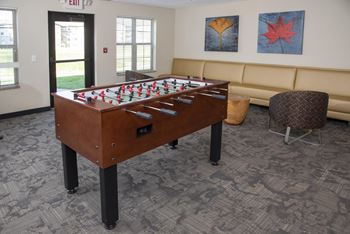 Foosball table in front of booth seating in the private gaming lounge.